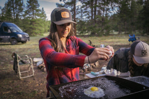 Blackstone Griddle being used to make eggs by a young woman.